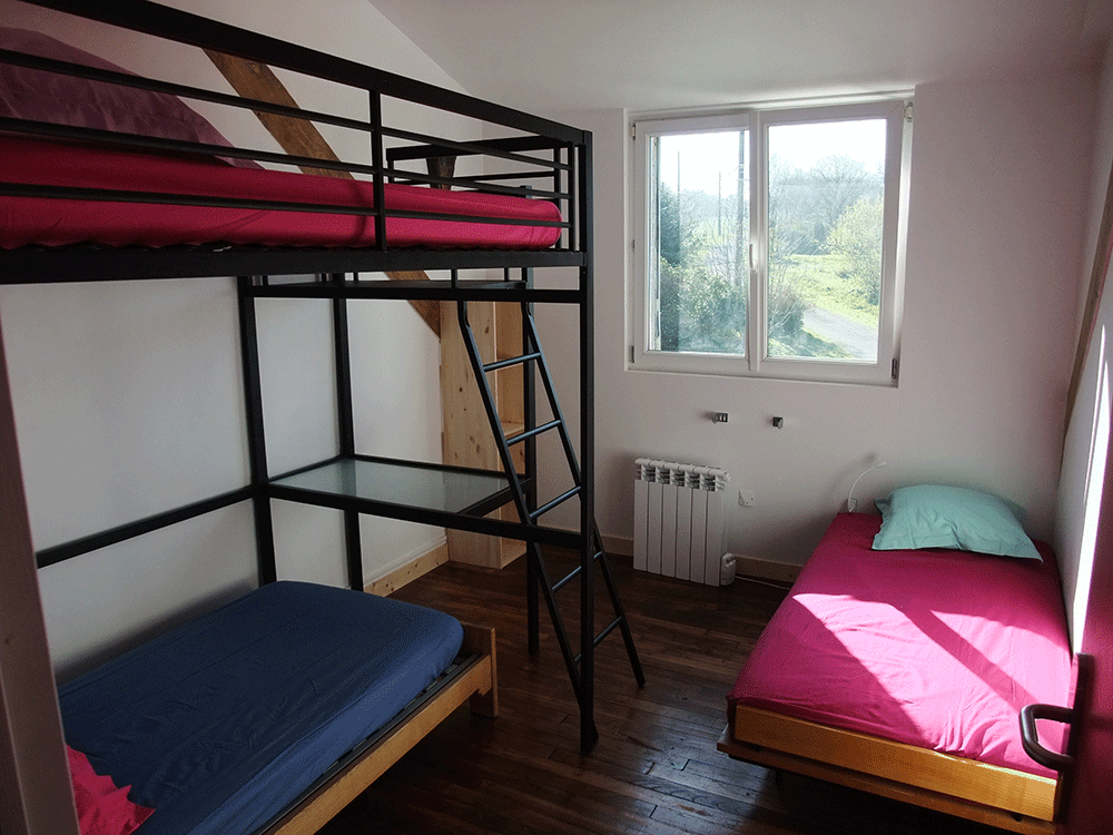 Une chambre du gîte avec un lit double en mezzanine. Location de gîte dans le Morbihan